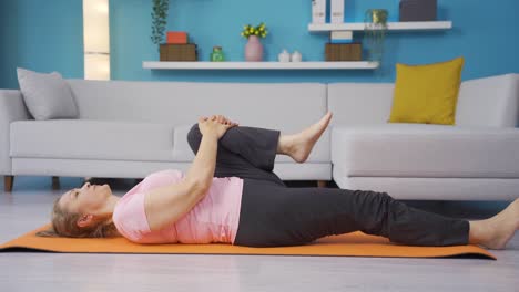 Woman-lying-on-floor-doing-stretching-fitness-moves.